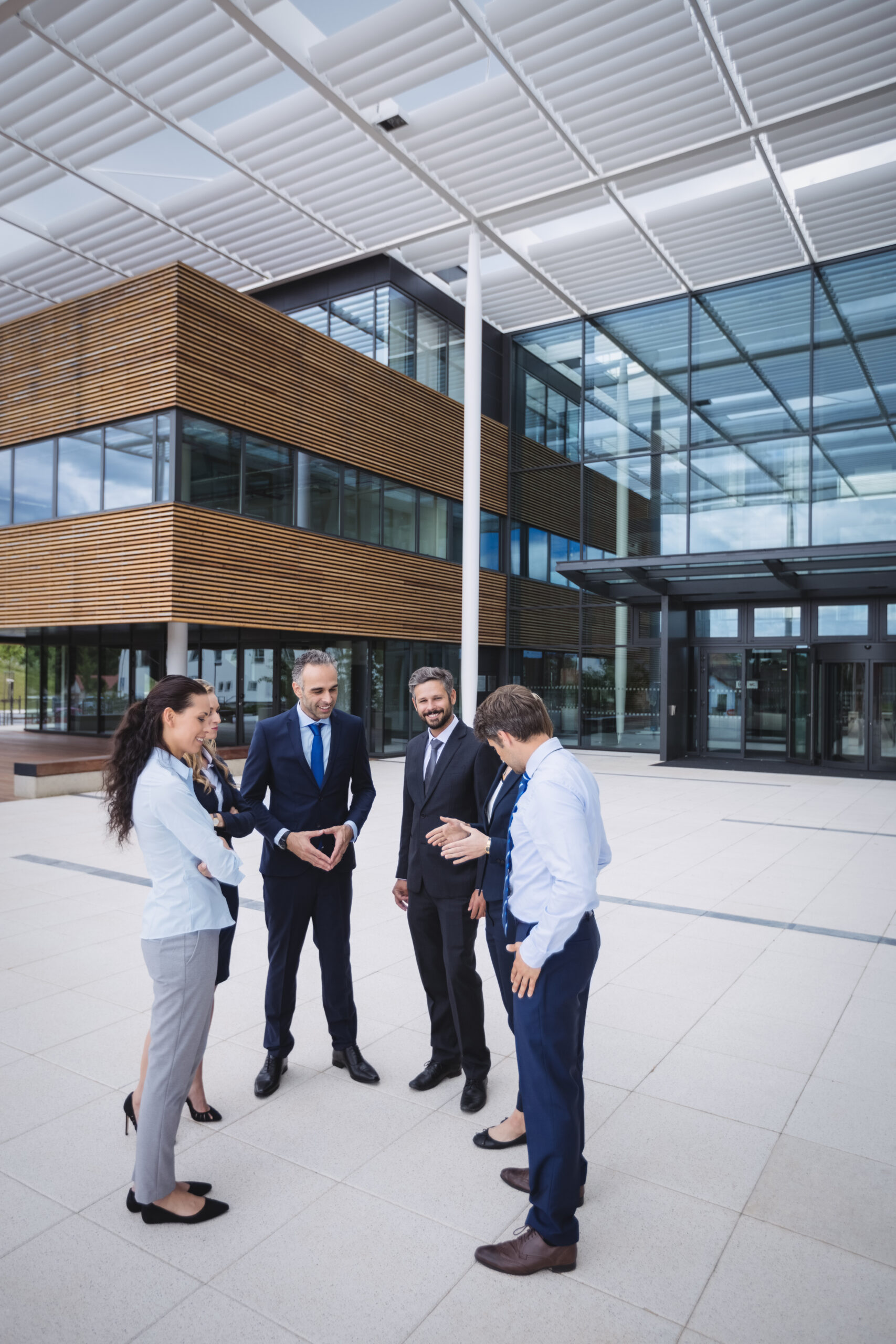 group of cheerful businesspeople interacting outside office building